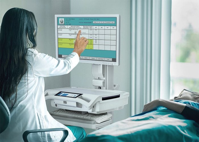 Nurse at bedside with Trio Computing Workstation on Wheels Hospital